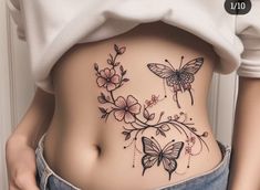 a woman's stomach with butterflies and flowers on the side, in front of her belly