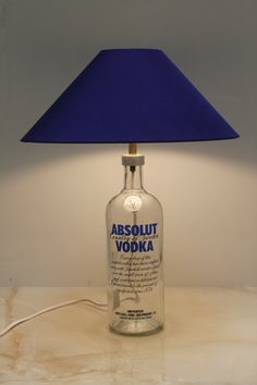 a lamp that is on top of a table with a bottle in front of it