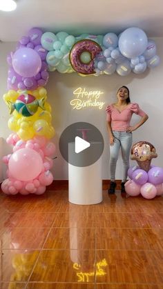 a woman standing in front of balloons and doughnuts