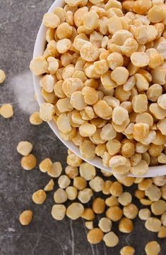 a white bowl filled with corn kernels on top of a table