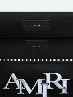 Accented with the season's embroidered AMIRI staggered logo, this utilitarian bag updates a classic silhouette through refinements in form and material. Adjustable straps with custom AMIRI hardware make this bag suitable for multiple stylings, from crossbody to belt bag wear. Pre-Spring 2024 Collection 100% NYLON DRY CLEAN ONLY Luxury Bags With Logo For On-the-go, Luxury Logo Bags For On-the-go, Leather Shoulder Bag With Embroidered Logo And Top Handle, Black Top Handle Shoulder Bag With Embroidered Logo, Black Shoulder Bag With Top Handle And Embroidered Logo, Leather Shoulder Bag With Embroidered Logo, Luxury Leather Shoulder Bag With Embroidered Logo, Luxury Embroidered Logo Crossbody Bag, Modern Rectangular Bag With Embroidered Logo