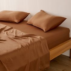 a bed with brown sheets and pillows on it