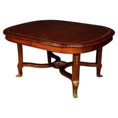 an oval wooden table with gold trimmings