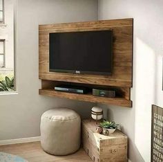 a tv mounted on the wall above a wooden shelf