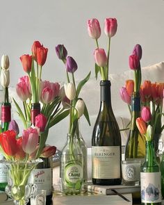 several bottles and vases filled with flowers on a table