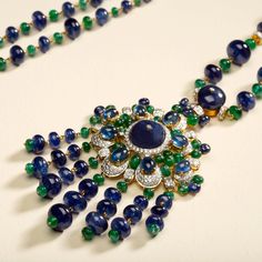 18 karat gold necklace with diamond, emerald and sapphire by fine jewelry designer ESTAA. “The Peacock Necklace” is a unique wearable art piece, weaving Indian tradition with contemporary design. Sapphire is said to be a stone of royalty bringing protection, power and strength. Whilst emerald has been known as a symbol of truth and love. 18 karat Gold 7.78 carats of diamonds brillant cut 7.61 carats of Emeralds 548.89 carats of Blue Sapphires Weight: 190g Width: 75 in. (19cm)Depth: 12 in. (30.5c Luxury Sapphire Pendant Necklace, Luxury Jeweled Pendant Jewelry, Elegant Sapphire Multi-stone Necklace, Elegant Blue Emerald Necklaces, Luxury Jeweled Emerald Jewelry, Hand Set Emerald Pendant Necklace, Luxury Green Sapphire Jewelry, Luxury Sapphire Necklace With Gemstone Accents, Luxury Diamond Jeweled Necklaces