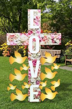 a cross that has flowers on it and the words love spelled in front of it