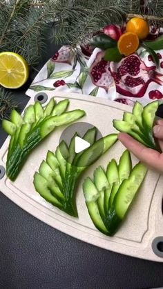 someone cutting up vegetables on a cutting board with lemons and pomegranates