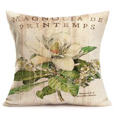 a pillow with a white flower on the front and green leaves on the back that says,