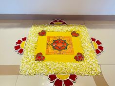 a yellow cake with red and white decorations on it's sides is sitting on the floor