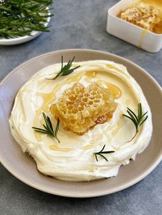 a plate topped with whipped cream and honeycombs next to a bowl of dip