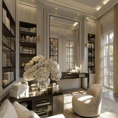 a living room filled with lots of white furniture and flowers on top of a table