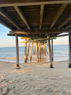 the underside of a wooden pier at the beach