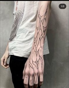 a person with a tattoo on their arm and hand is holding something in the air