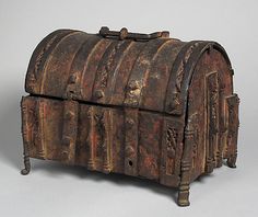 an old wooden chest with carvings on the front and sides, sitting on a gray surface