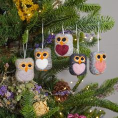 an ornament hanging from a christmas tree with three owls on it's sides