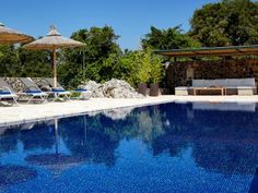 an empty swimming pool with lounge chairs and umbrellas