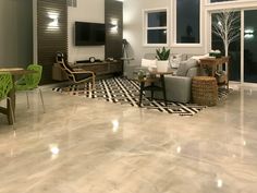 a living room filled with furniture and lots of windows next to a wall mounted tv