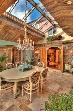 a dining room table with chairs and a chandelier hanging from it's ceiling