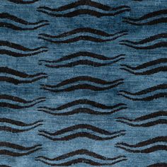 a blue rug with black wavy lines on the top and bottom, in an abstract pattern