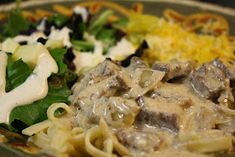 a plate with pasta, meat and vegetables on it