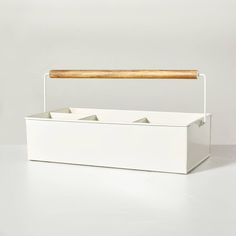 an empty white box with a wooden handle on the top and four compartments below it