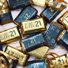 blue and gold birthday crackers with the number twenty one on them are surrounded by golden ribbons