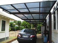 a car is parked in front of a house that has a metal awning over it