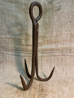 an iron hook with two hooks hanging from it's side on a burlock