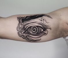 a man's arm with a black and white tattoo on it, depicting an eye