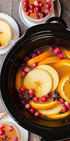 cranberry apple cider punch in a crock pot with orange slices and cinnamon sticks