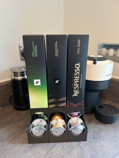 three different types of watches sitting on top of a counter next to a coffee maker