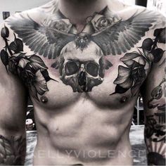 a man with tattoos on his chest has a skull and flowers in the middle of it