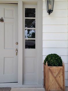 a white door with a planter in front of it