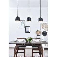 a dining room table with four lights hanging over it