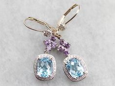 Easily transition from bridal to everyday wear with style in these lovely drop earrings! We've set amethyst floral drops with glittering diamond halos set with heavenly blue topaz gemstones, making a one of a kind pair of earrings that are the perfect gift for the bride to be! Metal: 14K White Gold, 18K White Gold Gem: 2 Blue Topaz Gem Measurements: 6.2 x 8.0 mm, Rectangle Cushion Cut Accents: 8 Amethyst, 48 Diamonds totaling .24 Carats, G in Color, VS in Clarity Earrings Length: 37 mm Earrings Gold Earrings Bridal, Rectangle Cushion, Gift For The Bride, Halo Setting, Diamond Glitter, White Gold Earrings, Diamond Drops, Diamond Drop Earrings, Bride To Be