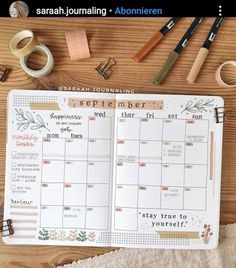 an open planner sitting on top of a wooden table