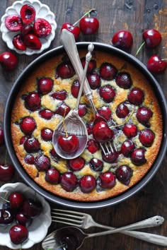 a cherry cobbler cake with cherries and a whisk