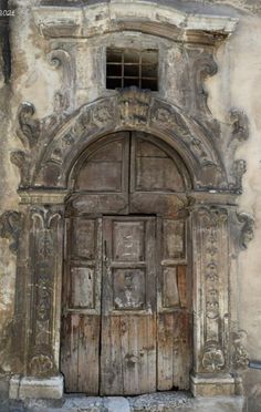 an old wooden door in front of a stone building