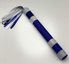 a blue and white pen with silver trimmings sitting on top of a table