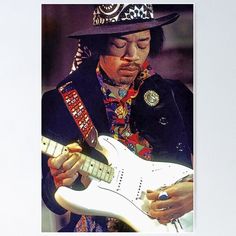 a man wearing a hat playing an electric guitar with his eyes closed and one hand on the neck