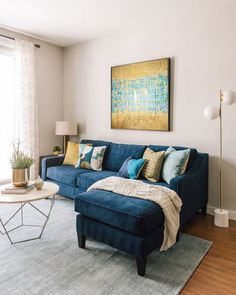 a living room with a blue couch and coffee table in front of a large window