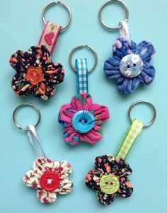 four different types of flower key chains on a blue background