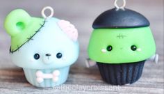 two small cupcakes are sitting next to each other on a wooden table, one is green and the other is black