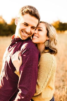 a man and woman hugging each other in a field