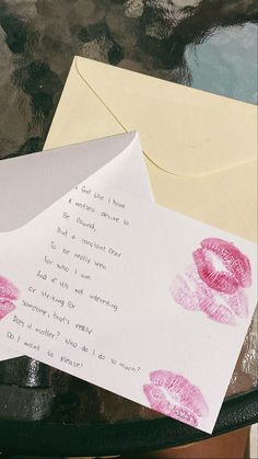 two envelopes with writing on them next to an envelope that has lipstick imprints on it