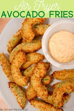 air fryer avocado fries on a white plate with dipping sauce in the middle