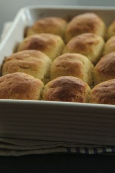 a pan filled with rolls and cheese on top of a table next to an alarm clock