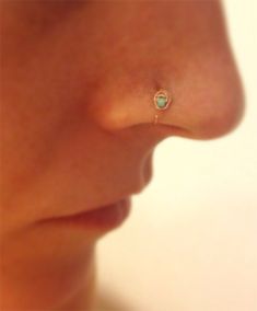 a woman's nose with a small turquoise stone in the middle of her nose