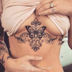 a woman's stomach with a butterfly tattoo on it